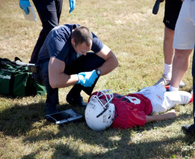 An EventMedix responder treating an injured player on the field