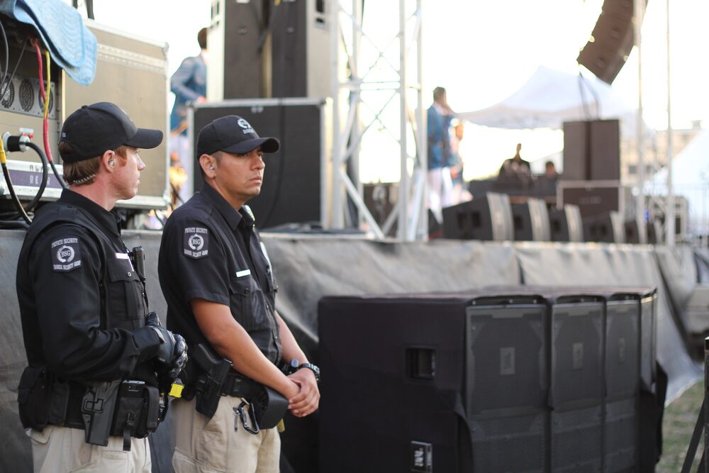 Uniformed security officers posted at the front of a concert stage